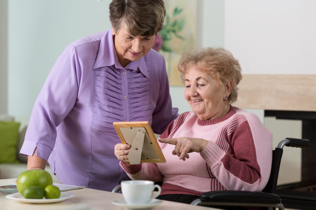 A volunteer from JSSA's Transitions program offers companionship to an elderly woman in a facility