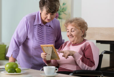 A volunteer from JSSA's Transitions program offers companionship to an elderly woman in a facility