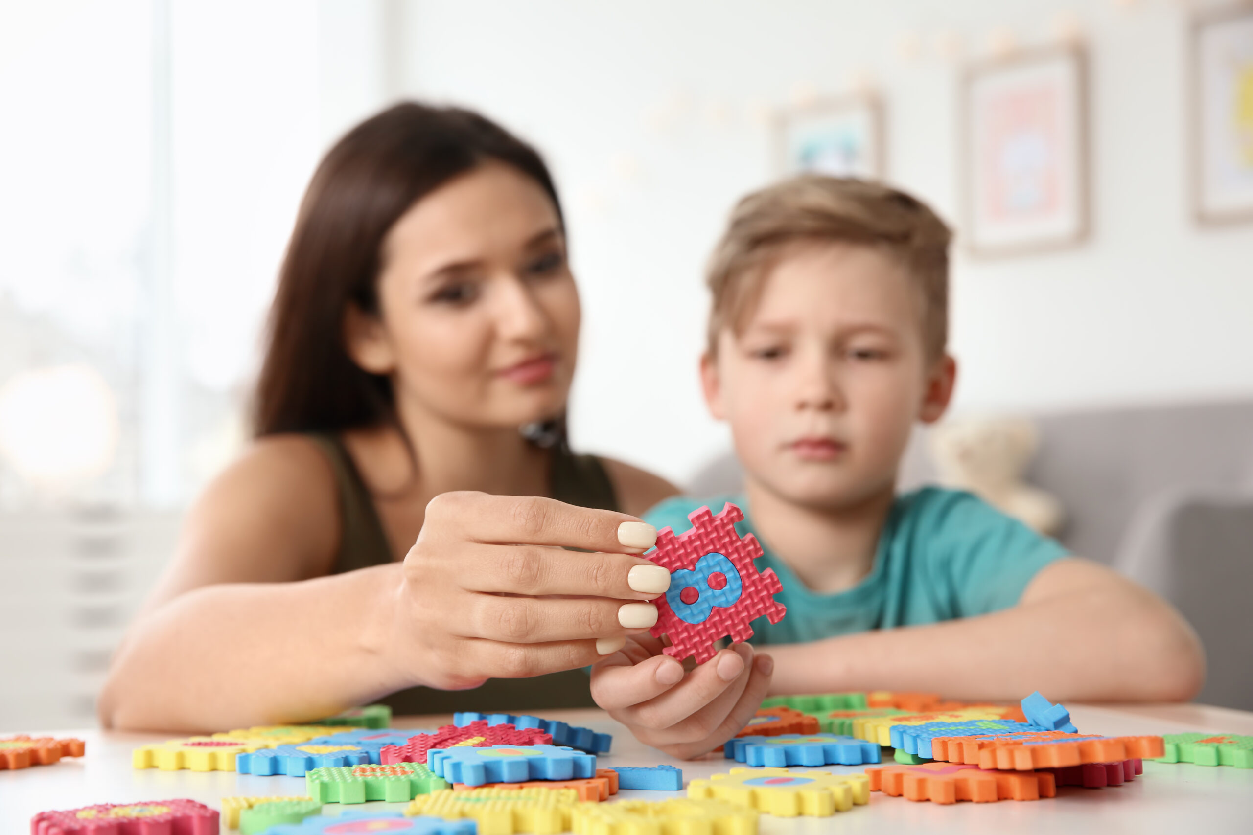 Woman playing a puzzle with boy