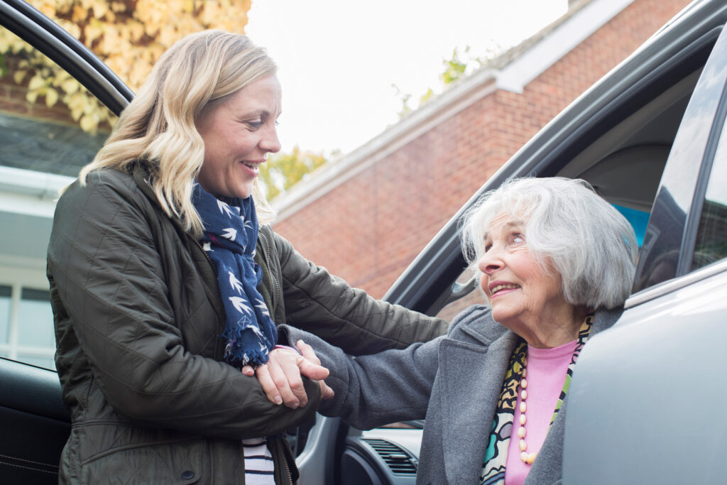 Young woman Giving Senior Woman A Lift In Car