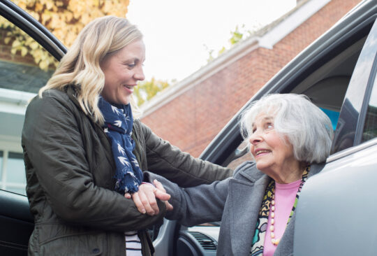 Young woman Giving Senior Woman A Lift In Car