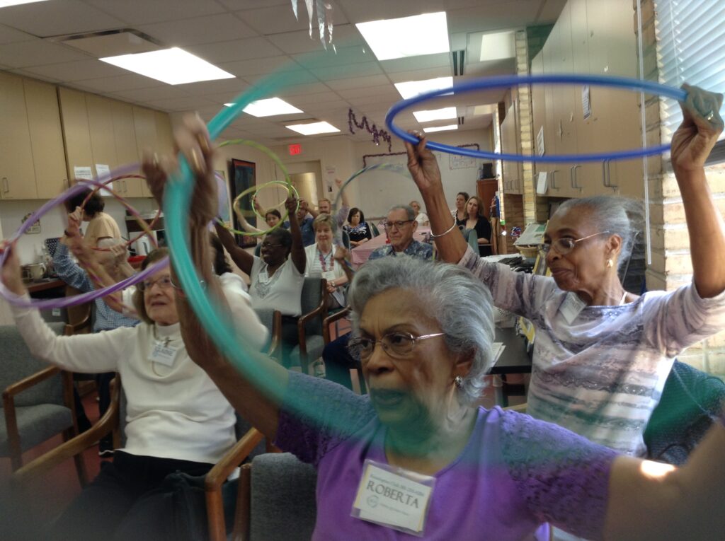 group of older adults doing activity with Hula Hoops