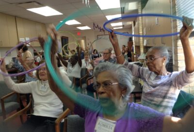 group of older adults doing activity with Hula Hoops