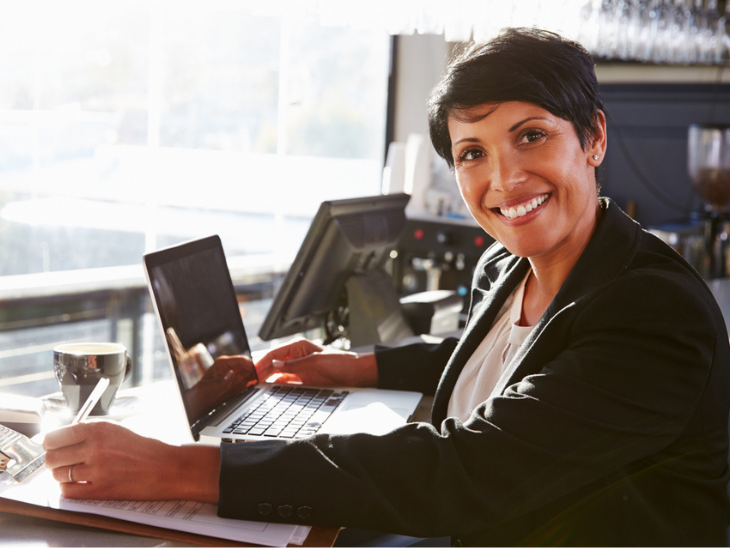 woman with laptop takes notes