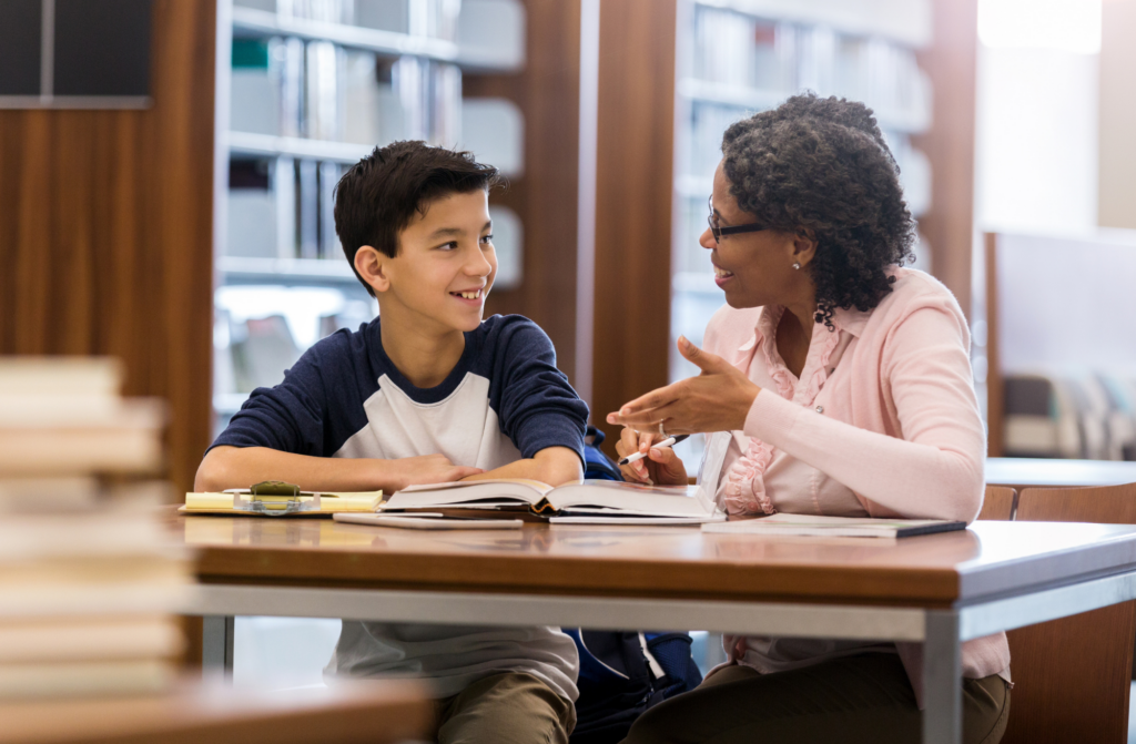 woman and boy talk in the library