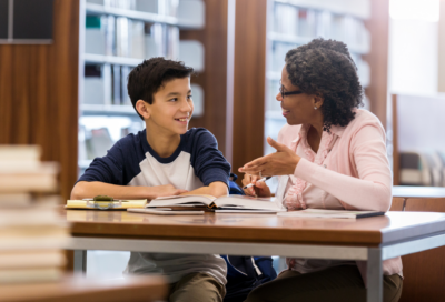 woman and boy talk in the library