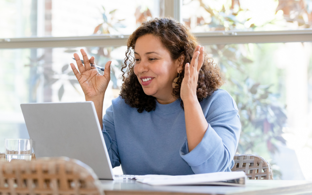 woman gesticulating as she speaks to a webinar on her laptop