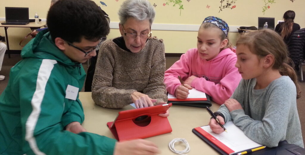woman and students examine content on ipad