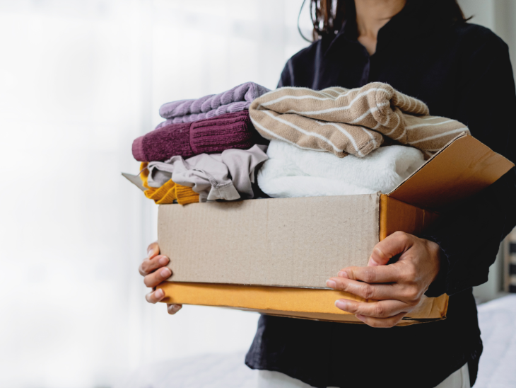 woman holds box of donated clothing